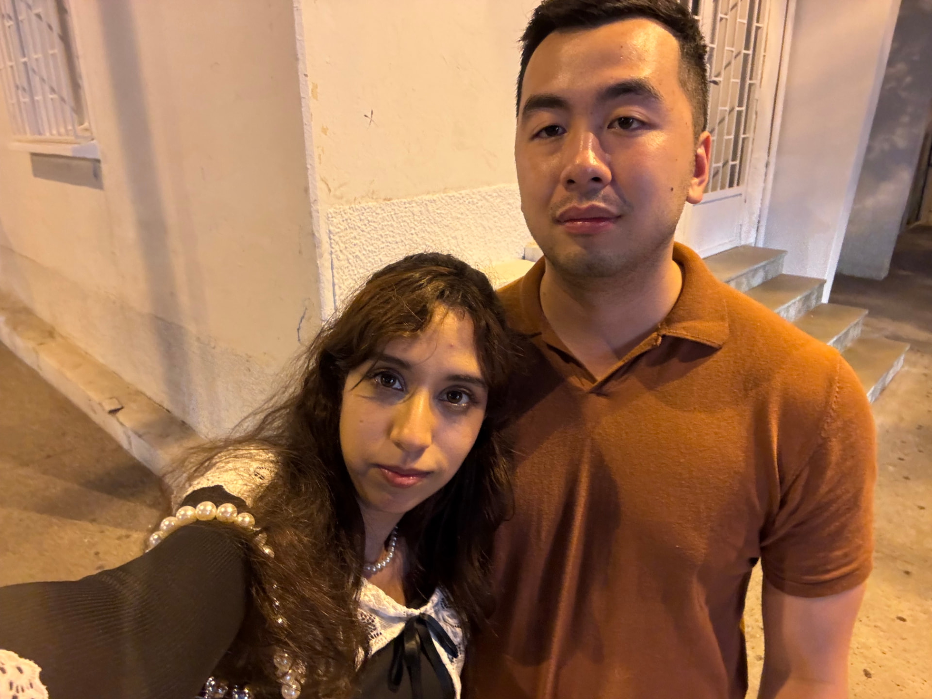 A couple taking a selfie while waiting outside at night